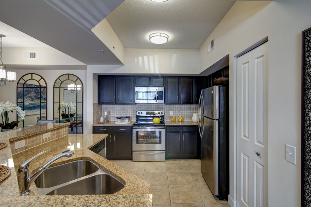 Open concept kitchen with island seating, stainless steel appliances, and tile backsplash