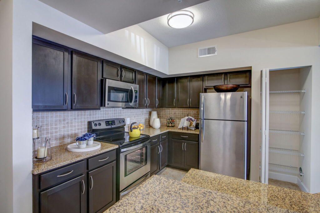 Open concept kitchen with island seating, stainless steel appliances, and tile backsplash