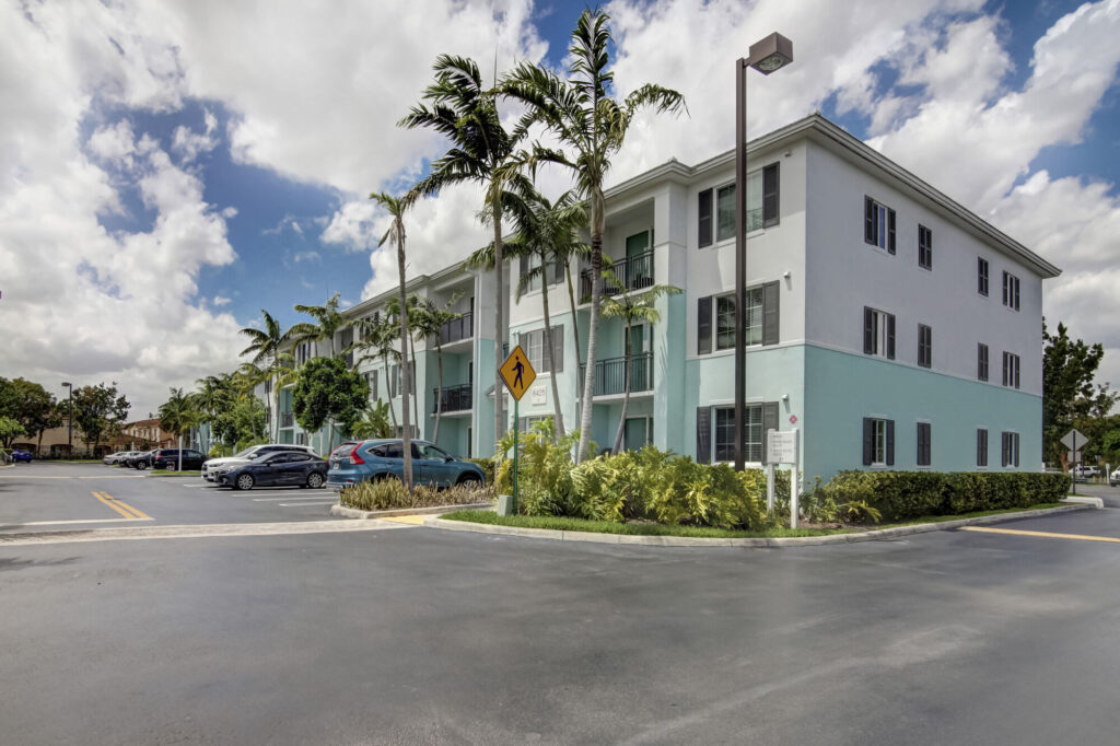 Building exterior with balconies and palm trees
